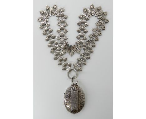 A VICTORIAN WHITE METAL LOCKET AND CHAIN the locket hallmarked Birmingham 1883, with spiral detail and floral engraving, dime