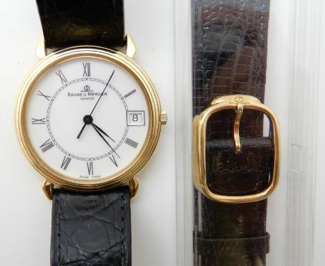 AN 18CT GOLD BAUME &amp; MERCIER WATCH with white dial black Roman numerals and date aperture, black leather strap with metal