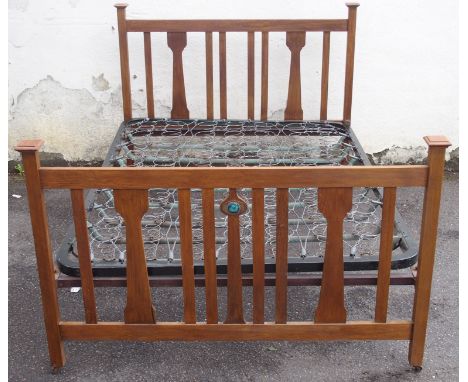 AN OAK ARTS AND CRAFTS DOUBLE BED with shaped slats with copper panel and ceramic roundel, 110cm high x 141cm wide x 207cm de