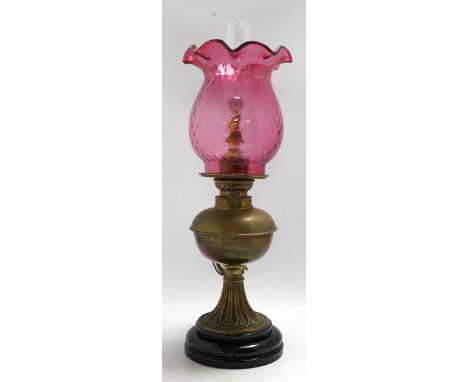 A Victorian brass oil lamp with cranberry glass shade. Condition - fair