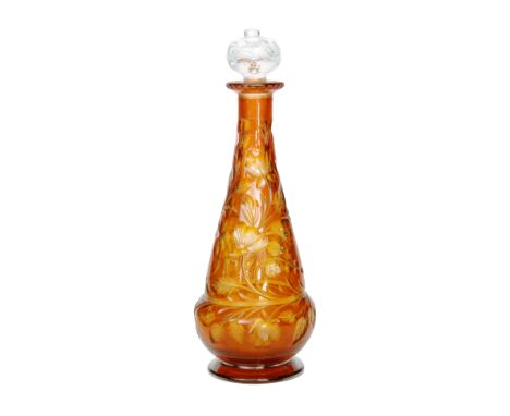 An early 20th Century Stevens & Williams spirit decanter of footed and tapered form, the body cased in deep amber over citron