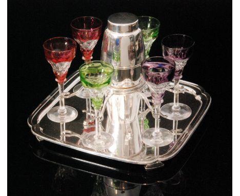 An early 20th Century cocktail set comprising silver plated square tray with cantered corners mounted with a central gallery 