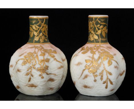 A pair of late 19th Century Harrach opal glass vases of fluted spherical form below a tall collar neck, relief gilt decorated