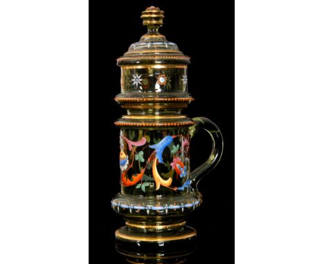 A 19th Century Bohemian beer stein of footed cylindrical form with applied loop handle and domed cover, enamel decorated with
