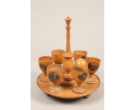 Scottish sycamore Mauchline ware egg epergne, with six egg cups and one egg, all decorated with black transfer prints of Ayrs