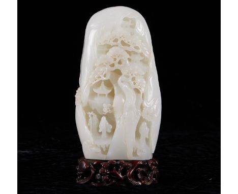 Chinese white jade boulder, deeply carved with a scene of figures, likely scholars or immortals, beneath the spreading branch