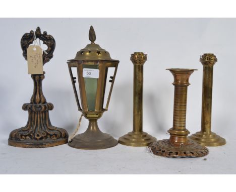 A Victorian cast iron doorstop along with a pair of art deco candlesticks on three tier bases , a pair of arts and crafts pie
