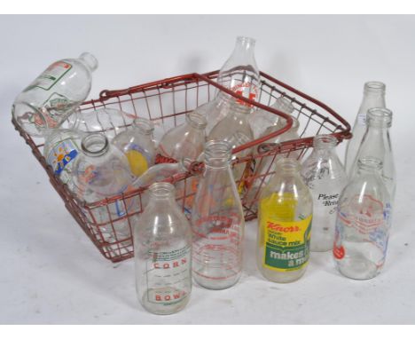 A collection of advertising milk bottles to include Crusha , all held within a vintage shopping basket