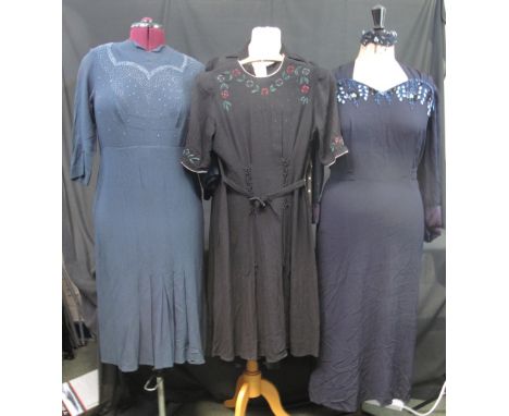 Four vintage 1940's dresses to include: a black knee length crepe belted dress with floral decoration and grey piping around 