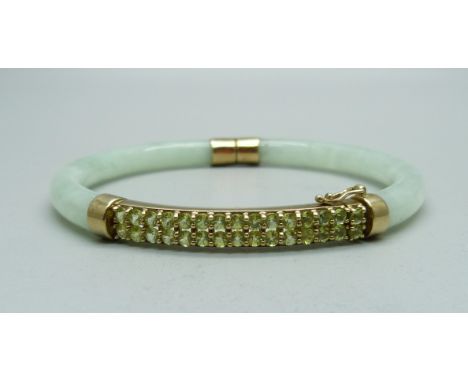 A 9ct gold and jade bangle set with green stones 