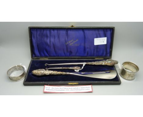 Two silver napkin rings, a cased shoe horn and button hook and one other button hook 
