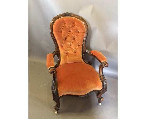 A Victorian Walnut Drawing Room Armchair, the button upholstered spoon back with carved cresting above the serpentine stuff o