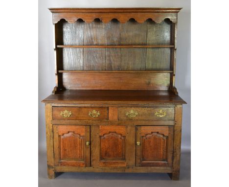 A George III Oak Dresser, the boarded shelf back above two drawers and two moulded doors with central panel flanked by stiles