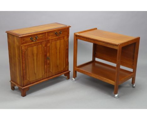 A teak rectangular two-tier tea trolley, 26¾” wide x 26” high; &amp; a yew wood dwarf cabinet fitted two frieze drawers above