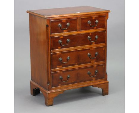 A reproduction yew wood small chest, fitted two short &amp; three long graduated drawers with brass swan-neck handles, &amp; 