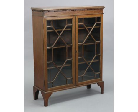 An Edwardian inlaid-mahogany china display cabinet with three adjustable shelves enclosed by a pair of glazed doors, &amp; on