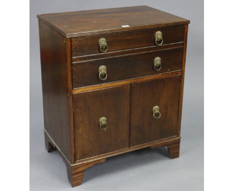 A reproduction mahogany chest commode with a hinged lift-top, mock-drawer front above cupboard enclosed by a pair of panel do