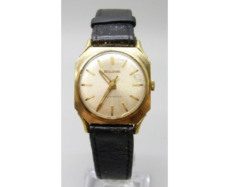 A 1960s Bulova wristwatch, gold plated octagonal case, automatic movement, on a black leather strap.