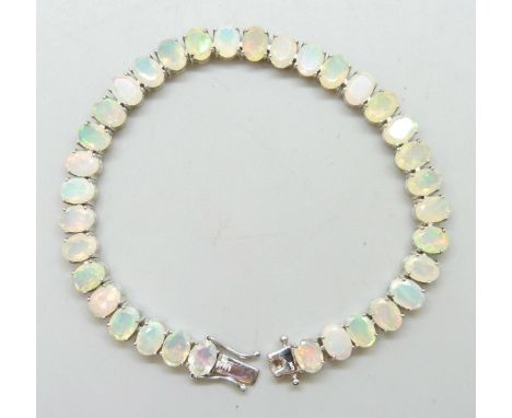 A silver and 19.39ct Ethiopian oval cut opal tennis bracelet, 15g
