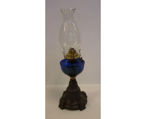 Early kerosene lamp with cast metal base and blue glass reservoir, 50cm high approx