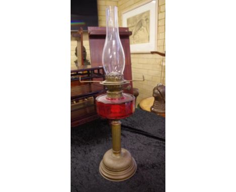 Antique oil lamp with dual burner & red glass font, 66cm high approx.