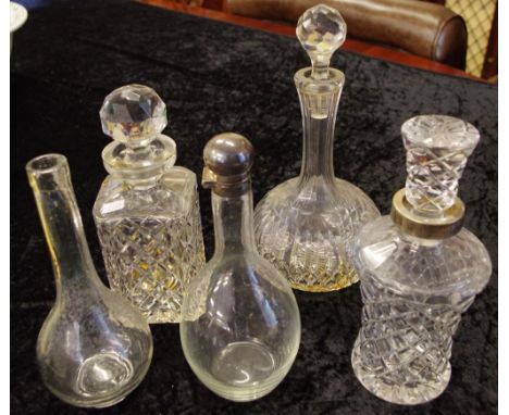 Four assorted crystal and glass decanters 2 with silver plated top rims, together with a glass decanter base