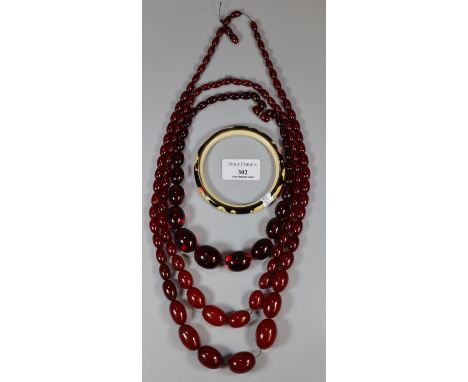 Three 1930s cherry Bakelite graduated necklaces. 164g approx. together with a Japanese design bangle with figures etc. (B.P. 