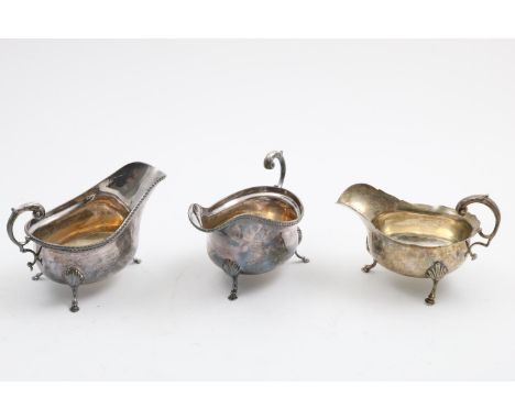 A PAIR OF ELIZABETH II SAUCE BOATS on three legs with leaf-capped scroll handles and gadrooned rims, by Carrington &amp; Co.,