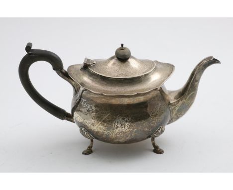 A GEORGE V TEA POT on four feet with a C-scroll handle and a shaped rim, initialled "OD" on one side, by G. Nathan and R. Hay