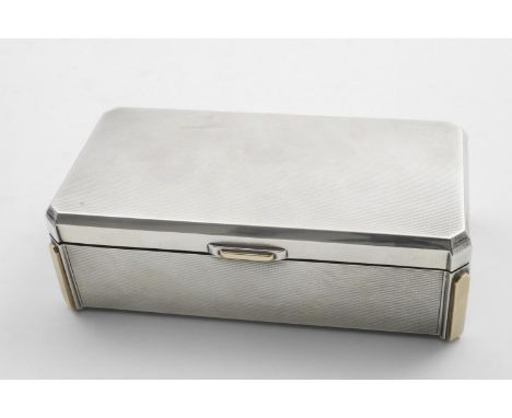 AN ART DECO RECTANGULAR CIGARETTE BOX with engine-turned decoration, architectural detail and applied gold decoration at the 