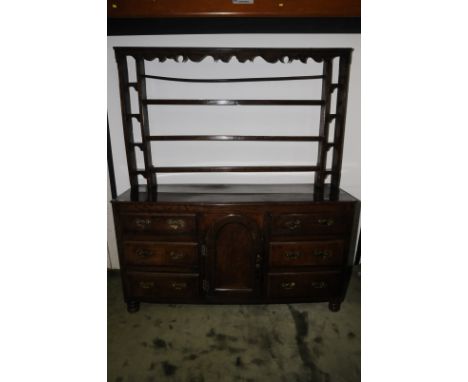 18th/19th C oak dresser with three tier central shelf rack with four flanking sections above central arched panelled cupboard