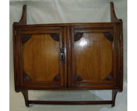 Oak wall hanging shelf / cabinet with two doors with carved detail revealing two interior shelves