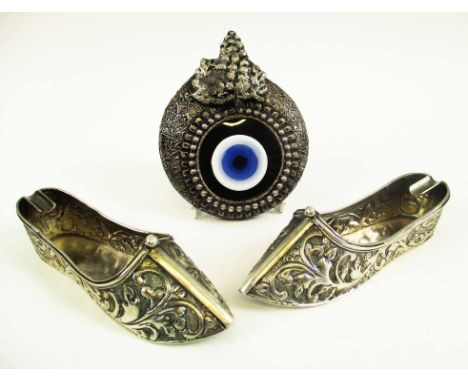 PAIR OF SILVER 'SLIPPER' ASHTRAYS, embossed foliate designs, marked '900' standard, 13cm L, 5.8oz, and a Nazar eye shaped amu