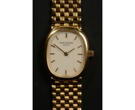 A LADY'S WRISTWATCH BY PATEK PHILIPPE in an 18ct gold case on an integral gate bracelet, the oval cream dial with gilt batons