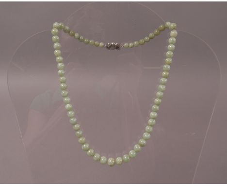 A JADE NECKLACE of graduated spherical beads, approximate maximum diameter 9.25mm to minimum diameter 6mm, fastened with a pe