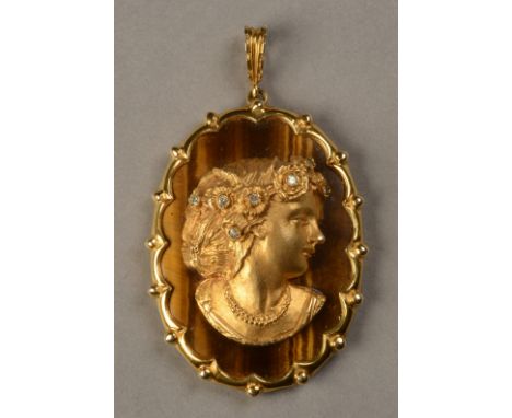 A TIGER-EYE AND DIAMOND PENDANT in 9ct gold, the female portrait in half relief, set to the dressed hair with small eight cut