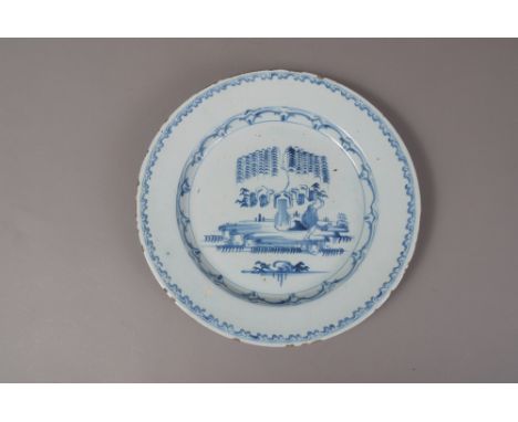 AN ENGLISH BLUE AND WHITE DELFTWARE CHARGER, mid 18th century, decorated with a Chinese figure, stylised rockwork and tree, 3