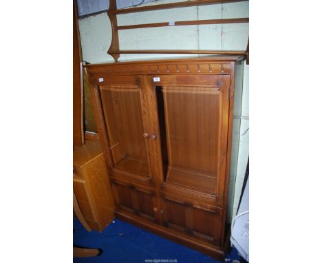 An Ercol "Old Colonial" Oak Display cabinet with glazed doors, 40'' wide x 12'' deep x 54'' high and an Ercol plate rack.