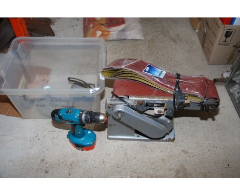 A Makita cordless drill (charger absent) and a Nu-tool table belt Sander.