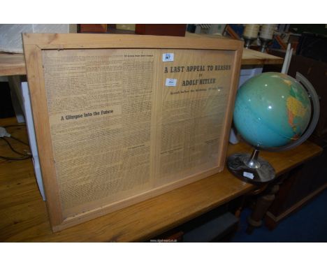 A framed newspaper article and a globe.