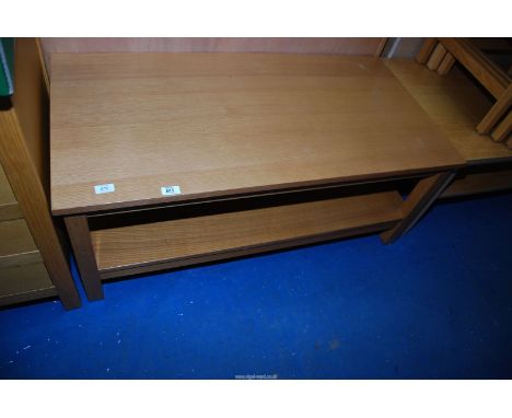 A light oak coffee table with lower shelf, 43 1/2'' x 22'' x 18'' high.