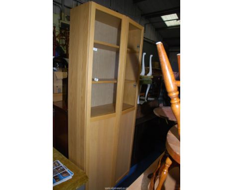 A light oak effect cabinet with glazed doors revealing six adjustable shelves, 80'' x 12'' x 32'' wide.