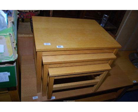 A nest of three light oak tables.