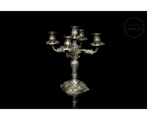 Silver candlestick with five lights and vegetal designs in relief. With counterweight. Silver marks on the base.Size: 31,3 x 