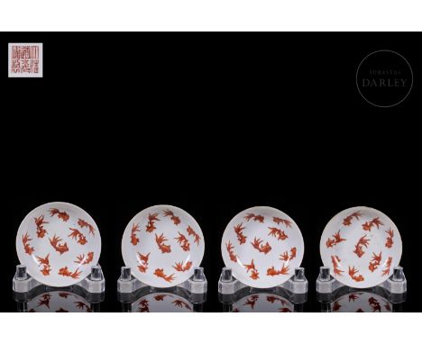 A set of four porcelain plates, decorated with a beautiful iron-red enamel on a white glaze background. The front side shows 