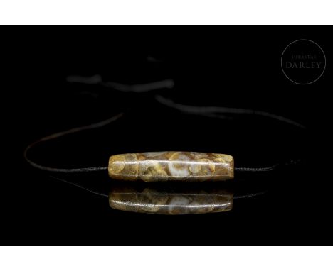 Ancient phaluo bead or ‘????’ carved in the shape of an elongated sheath, with rounded edges and a central hole that runs thr