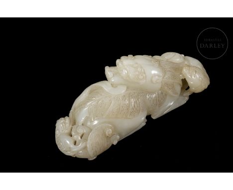 White jade carved in the form of a mythical beast. It shows a large mother, with fine, long fur, a recumbent body, her legs b