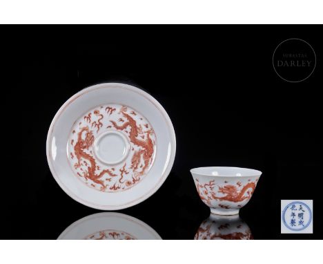 A set of glazed porcelain plate and cup with iron-red enamel decorations. Both pieces are decorated with a pair of fierce fou