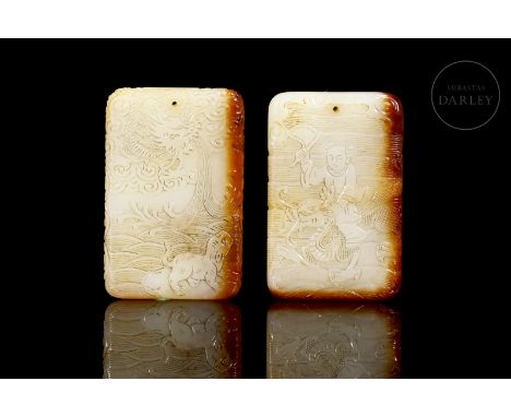 Two light-coloured jade plaques with reddish flecks. Carved in rectangular format, with rounded edges, they show a profusely 
