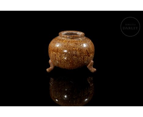 Ceramic modelled in the form of a censer, with a rounded body on three curved legs and a small mouth with a turned rim. It is